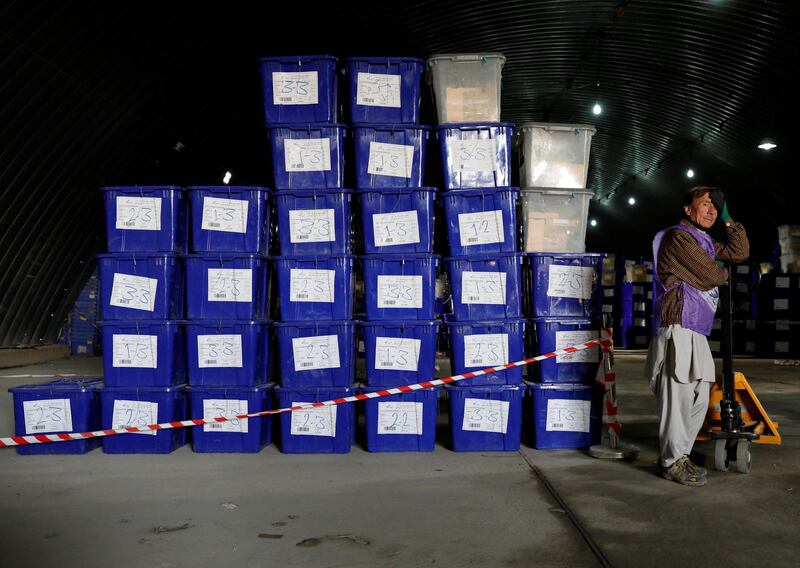 An Afghan election commission worker stands next to ballot boxes and election material in a warehouse in Kabul, Afghanistan October 18, 2018.REUTERS/Mohammad Ismail