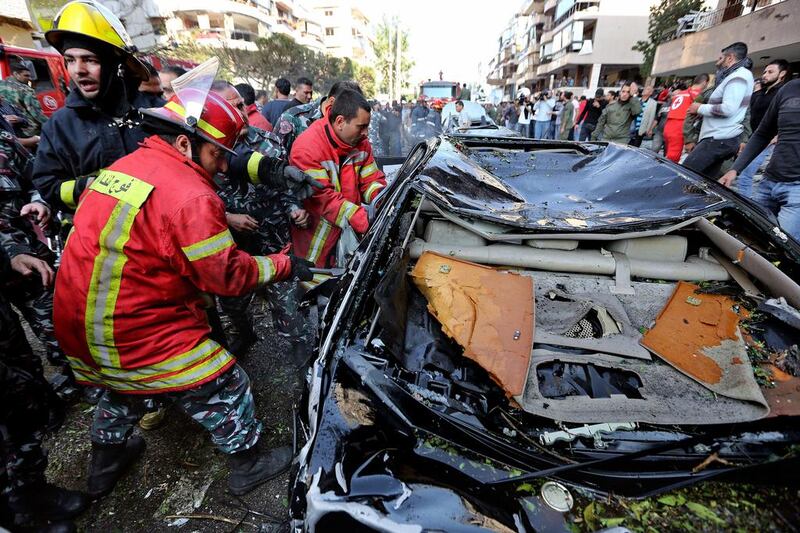 Lebanese Red Cross workers try to rescue to a person from a car wrecked by the blast. Bilal Hussein / AP Photo