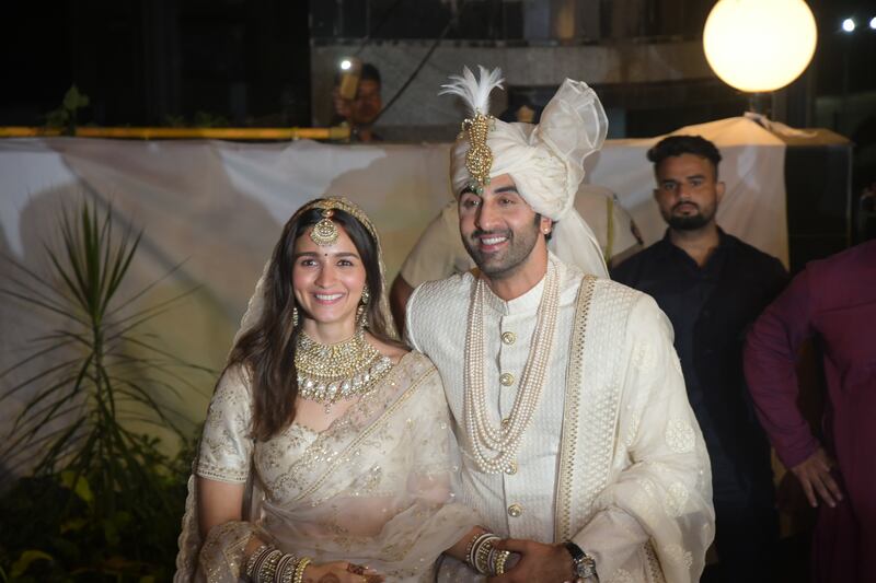 The happy couple hold hands after the wedding.