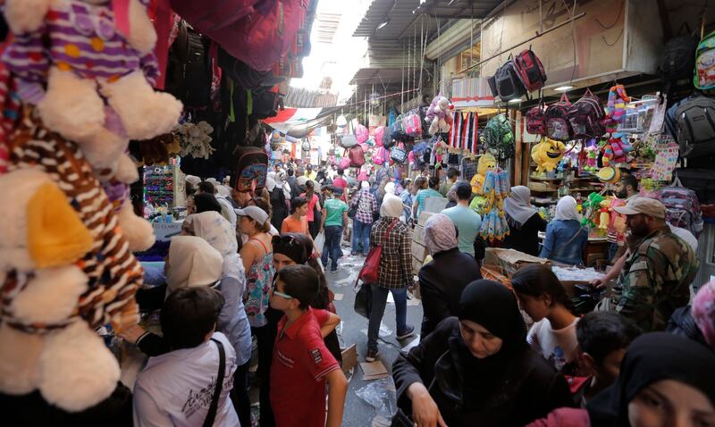 Syrians buy clothes and stationery for their children in one of the souks of the capital Damascus, one day ahead of the start of the new academic year. EPA