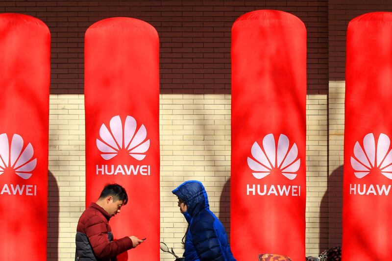 People walk past logos of Huawei in Huaian, Jiangsu province, China January 26, 2019. Picture taken January 26, 2019. REUTERS/Stringer  ATTENTION EDITORS - THIS IMAGE WAS PROVIDED BY A THIRD PARTY. CHINA OUT. NO COMMERCIAL OR EDITORIAL SALES IN CHINA.