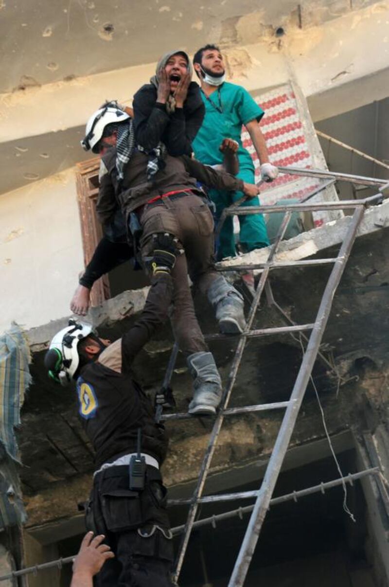 Syrian civil defence volunteers evacuate people from a damaged building following a reported airstrike in the rebel-held neighbourhood of Tareeq al-Bab in the northern city of Aleppo. Ameer Alhalbi / AFP