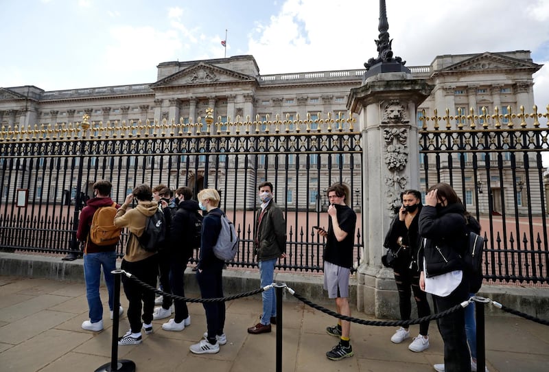 People wait in a line to view the announcement at Buckingham Palace. AP Photo