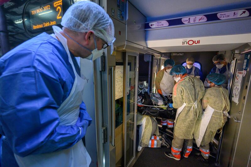 Medical staff carry a patient infected with the Covid-19 onboard a medicalized TGV high speed train at the railway station in Strasbourg. Pool via Reuters
