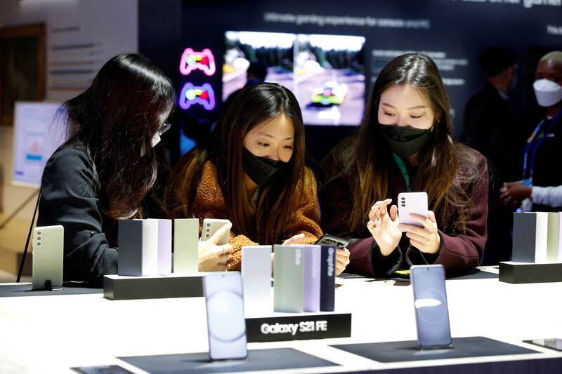 Attendees try out the Samsung Galaxy S21 FE phone at the technology show. Reuters