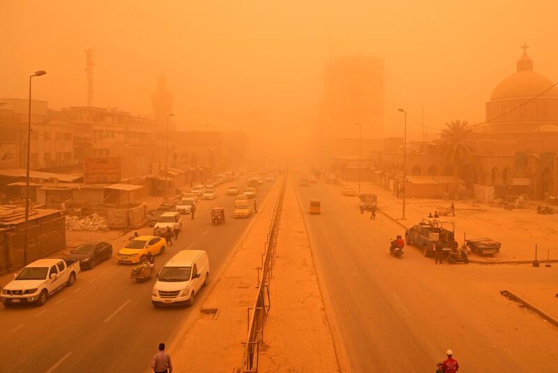 People travel along a street during a sandstorm in Baghdad. AP Photo