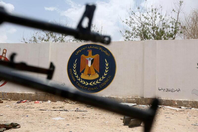 FILE PHOTO: The emblem of the STC is seen between weapons held by Yemeni government soldiers at the headquarters of the separatist Southern Transitional Council in Ataq, Yemen August 27, 2019. REUTERS/Ali Owidha/File Photo