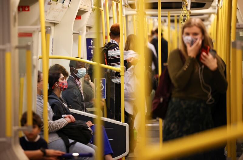 People wearing face masks ride aboard a London Underground train. Reuters
