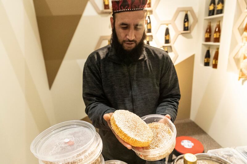 Afghani Faisal Khan from Al Mulook Honey displays fresh honey cakes that are for sale.