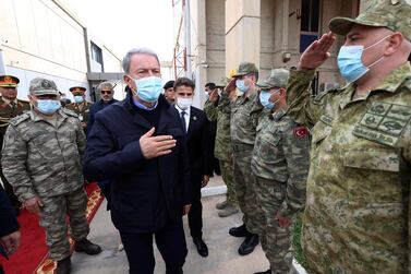 Turkey’s Defence Minister Hulusi Akar, centre, and Turkey’s chief of staff, General Yasar Guler, left, greet Libyan and Turkish commanders commanders, in Tripoli, Libya, on Saturday, December, 26, 2020. AP