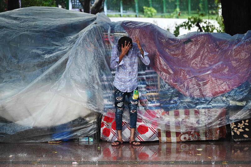 A man tries to take cover from the rain in New Delhi, India. AFP