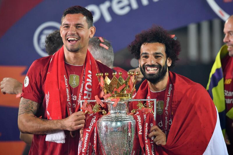 Liverpool superstar Mohamed Salah wears an Egyptian flag around his shoulders as he celebrates with Dejan Lovren and the trophy after winning the Premier League. AFP