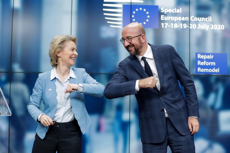 TOPSHOT - European Commission President Ursula Von Der Leyen (L) and European Council President Charles Michel (R) bump elbows at the end of the news conference following a four days European summit at the European Council in Brussels, Belgium, early July 21, 2020.  EU leaders approved a 750-billion-euro package to revive their coronavirus-ravaged economies after a tough 90-hour summit on July 21, along with a trillion-euro budget for the next seven years. / AFP / POOL / STEPHANIE LECOCQ
