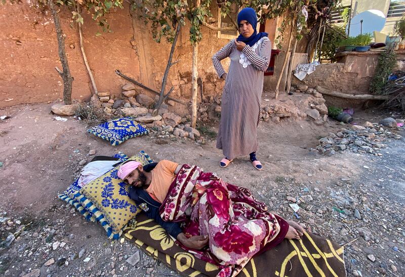 An injured man lies on the ground as he and his wife prepare to spend a second night in the open air in the village of Tansghart, Morocco. Reuters