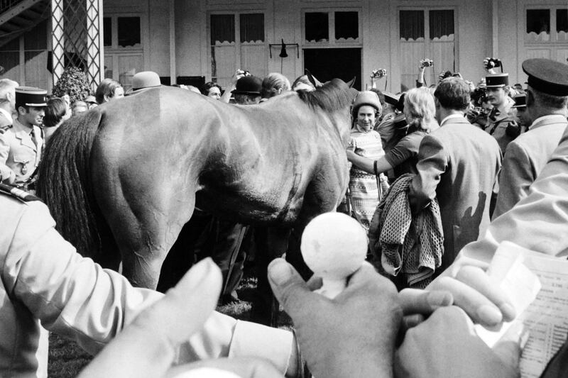 Queen Elizabeth II greets her British thoroughbred racehorse, Highclere, in the paddock during the Prix de Diane, on June 16, 1974 in Chantilly, France. AFP
