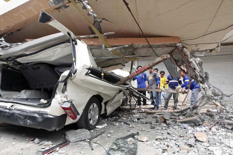Residents inspect a car after a concrete block fell on it during an earthquake in Cebu city, central Philippines. Reuters/Stringer  