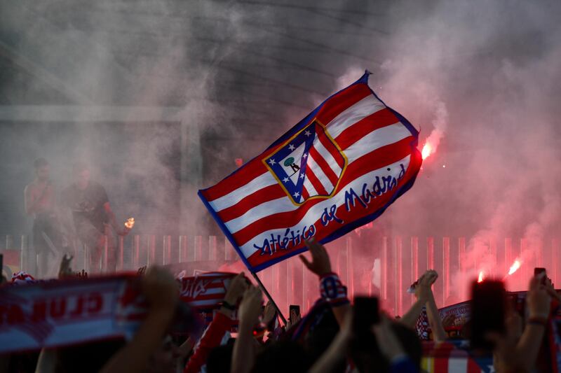 Atletico Madrid fans wave flags and set off flares in celebration outside the stadium after the match. Reuters