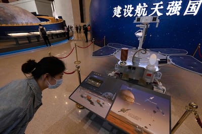 A visitor to an exhibition on China's space program looks at a life size model of the Chinese Mars rover Zhurong, named after the Chinese god of fire, at the National Museum in Beijing on Thursday, May 6, 2021. China has landed a spacecraft on Mars for the first time in the latest advance for its space program. The official Xinhua News Agency said Saturday, May 15, that the lander had touched down, citing the China National Space Administration. Chinese characters read: Build a Space Power. (AP Photo/Ng Han Guan)