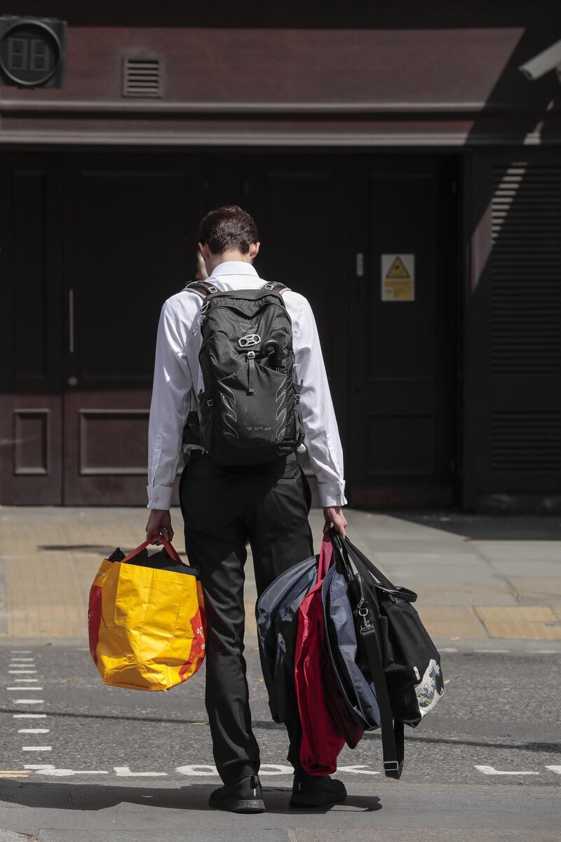 A man holds bags and suit carriers as he leaves the offices of Deutsche Bank in London, UK, on Monday.  Bloomberg