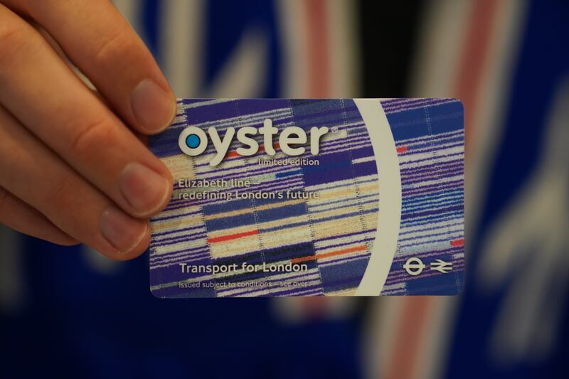 A passenger holds a new Elizabeth Line Oyster public transport payment card design. PA