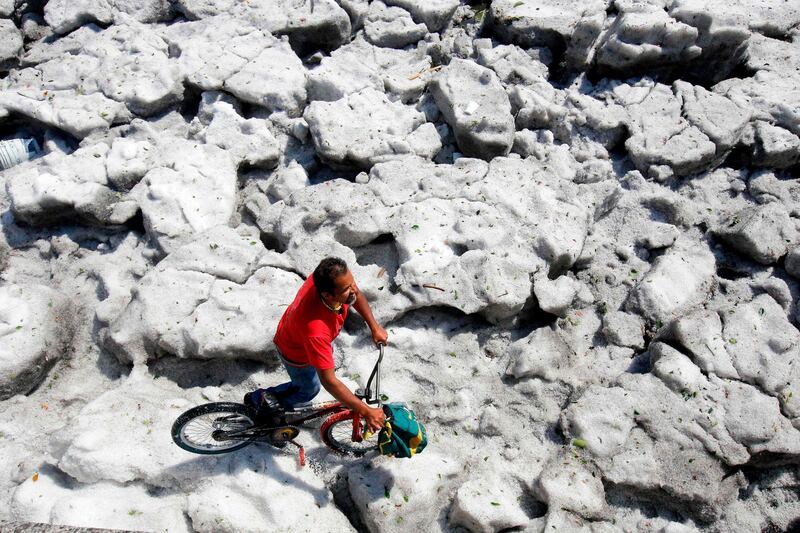 A man with a bike walks on hail in the eastern area of Guadalajara, Mexico. AFP