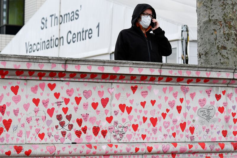 A man stands behind the National Covid Memorial Wall in London. Reuters