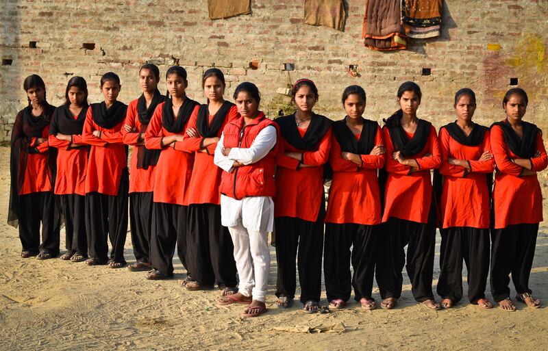 Young women from the Red Brigade walk through the Midiyav slum in the city of Lucknow. Their leader, Usha Vishwakarma, 25, is in white. The Red Brigade was formed in November 2010 to fight back against a growing number of sexual attacks on women in the Madiyav area of the city of Lucknow, in Uttar Pradesh state, India.
The group of young women wear distinctive red and black salwar kameez. Most have been victims of sexual assault and have resolved that they will take no more. They take direct action against their tormentors and now when a local man steps out of line, he can expect a visit from the Red Brigade and a thrashing.