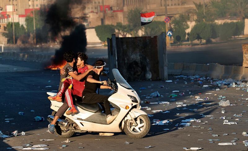 An injured protestor is rushed to the hospital after being shot during a demonstration in Baghdad, Iraq.    AP