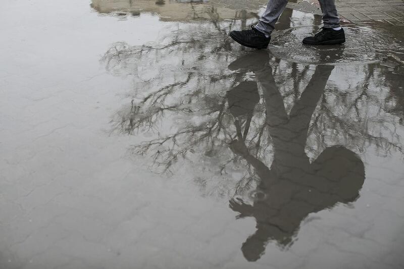 Residents navigate a flooded street in Abu Dhabi. Mona Al Marzooqi / The National