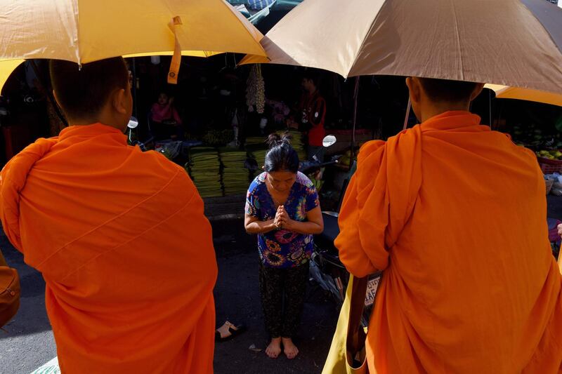 A Cambodian woman prays before Buddhist monks at a market in Phnom Penh.  AFP