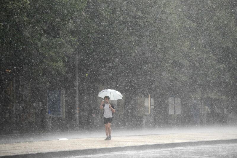 A man walks accross the Wenceslas Square as a heavy rain storm hits Prague.  AFP