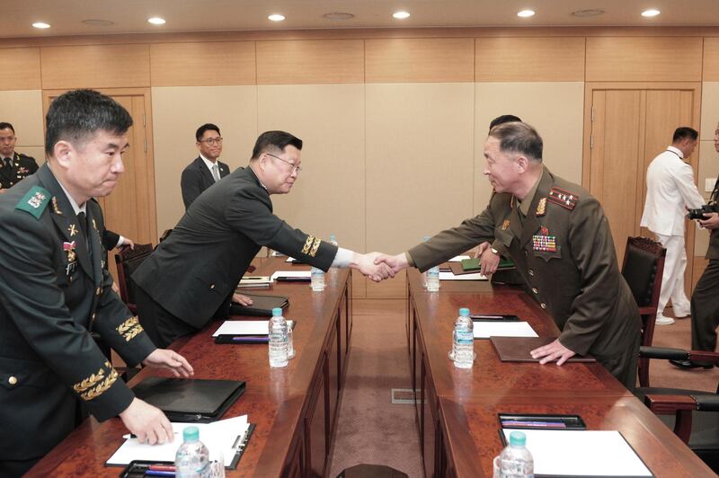 In this photo provided by South Korea Defense Ministry, North Korean army Col. Om Chang Nam, right, shakes hands with his South Korean counterpart Col. Cho Yong-geun during a meeting at the Customs, Immigration, and Quarantine office in Paju, South Korea, Monday, June 25, 2018. Military officers from the two Koreas on Monday met to discuss how to fully restore their military hotline communication channels, according to the South's Defense Ministry. (South Korea Defense Ministry via AP)