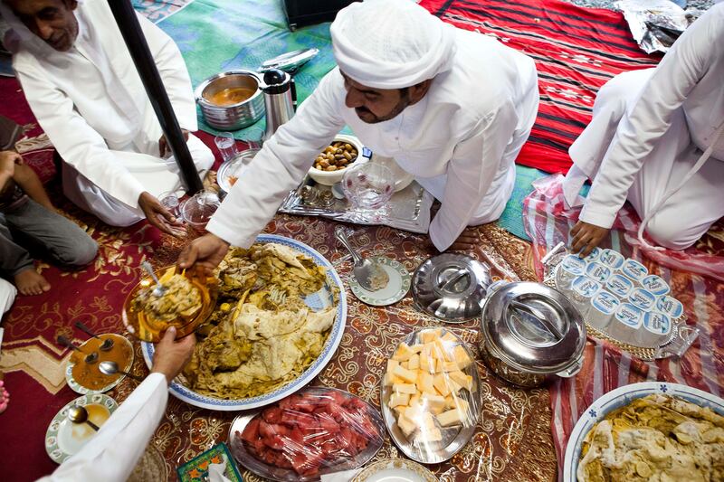 June 17, Abdullah Al Yalyle dishes up for his guests during a traditional meal at his home Majlis in Wadi Al Tuwa.  June 1, Ras Al Khaimah, United Arab Emirates. (Photo: Antonie Robertson/ The National)