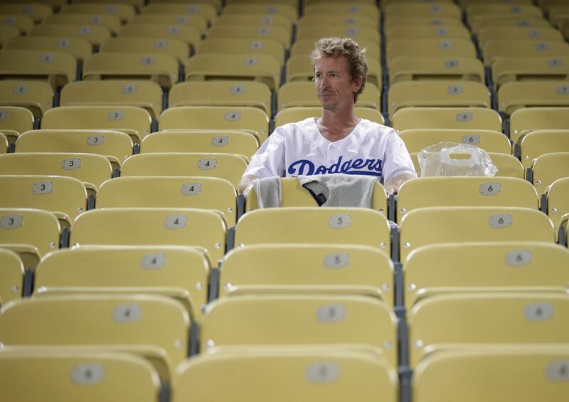 A Los Angeles Dodgers fan sits in the stands after the game. AP Photo