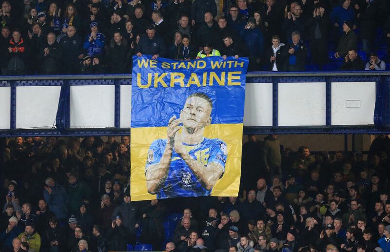 Everton fans hold a banner in the colours of the Ukraine national flag, and depicting Ukrainian defender Vitaliy Mykolenko. AFP