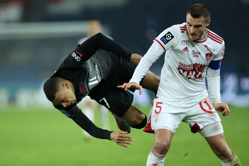 Paris Saint-Germain's French forward Kylian Mbappe falls down in front of Brest's French defender Brendan Chardonnet. AFP