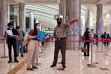 An Emirati policeman directs a tourist to a medical screening centre on arrival at Teminal 3 at Dubai airport, in the United Arab Emirates. AFP