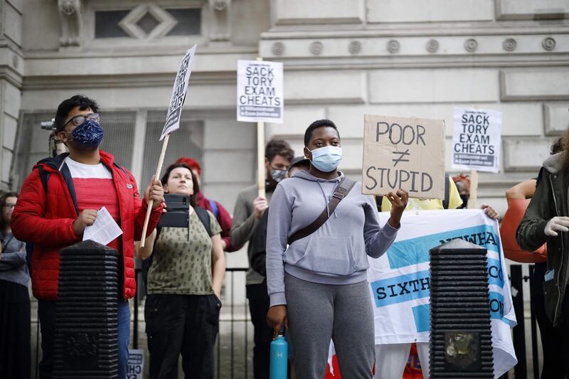 People including students hold placards on Whitehall outside Downing Street in London on August 14, 2020 as they protest against the downgrading of A-level results. The British government faced criticism after education officials downgraded more than a third of pupils' final grades in a system devised after the coronavirus pandemic led to cancelled exams. / AFP / Tolga Akmen

