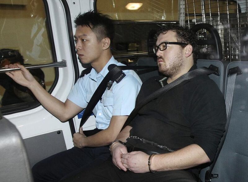 Rurik Jutting, right, a 29-year-old British banker, has been charged with two counts of murder. He is seen here inside a police van as it arrived at a court in Hong Kong on November 3, 2014. Apple Daily/Reuters