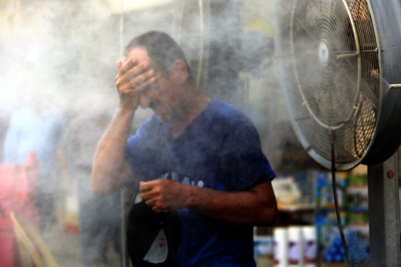 An Iraqi man cool himself off in a spray of water during a sweltering hot day at the Al-Khilani square in central Baghdad, Iraq, 19 July 2022.  Baghdad suffers a heatwave as temperatures rose to more than 50 degrees Celsius, amid an acute shortage of electricity.   EPA / AHMED JALIL