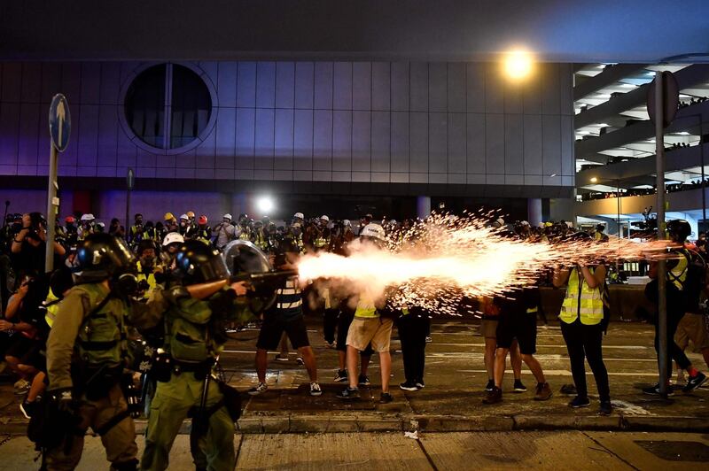 A policeman fires tear gas at protesters to disperse them after a march against a controversial extradition bill in Hong Kong. Hong Kong descended into chaos on the night of July 21 as riot police fired multiple volleys of tear at anti-government protesters, hours after China's office in the city was daubed with eggs and graffiti in a vivid rebuke to Beijing's rule.   AFP