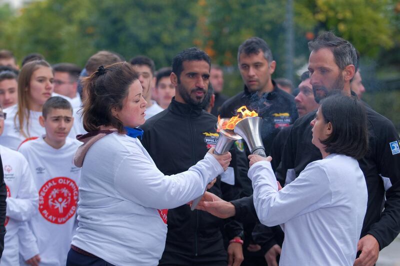 Special Olympics Hellas athletes transferring the Flame of Hope during the Torch Run through Athens.