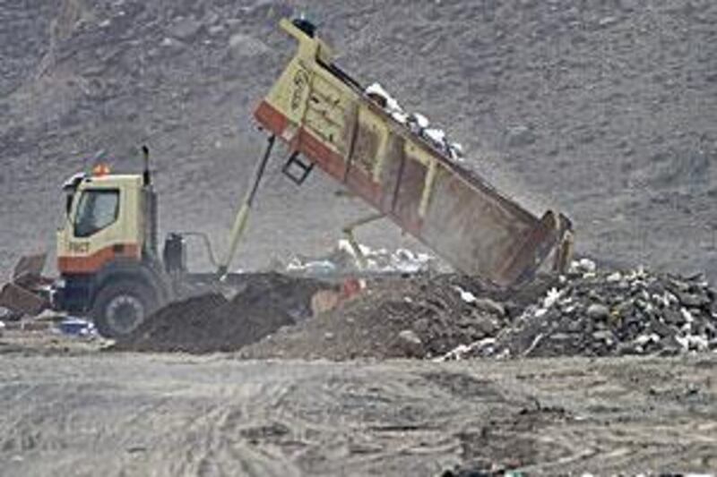 A driver ignores a Fujairah Municipality sign at a site near Fujairah City stating that it is illegal to dump rubbish.