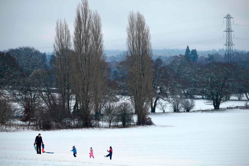 Children make their way back up the hill after riding a sled down a snow-covered field beside St. Mary's Church after heavy snowfall in Hartley Wintney, west of London. AFP