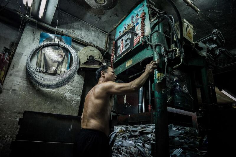 A worker activates an hydraulic press at a waste paper collection outlet in Hong Kong.  Philippe Lopez / AFP Photo