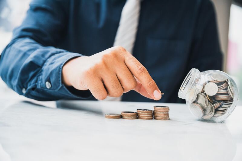 Close up businessman holding putting money coin stack with coin in glass. Investment concept, Saving money concept, Finance money concept