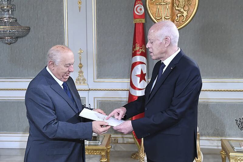 Sadok Belaid, left, head of Tunisia’s constitution committee, submits a draft of the new constitution to President Kais Saied. AFP