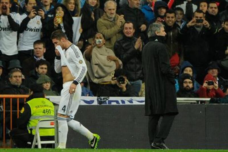 Real Madrid defender Sergio Ramos walks off the field past Jose Mourino after his red card against Ray Vallecano.