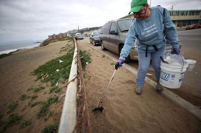 PACIFICA, CALIFORNIA - APRIL 3: Terri Brown, a volunteer with Pacific Beach Coalition, uses a grabber tool to pick up a discarded surgical mask while picking up trash near Pacifica Esplanade Beach on April 3, 2021 in Pacifica, California. Concerns are growing over discarded COVID-19 related used personal protective equipment (PPE) that is littering streets and waterways since it contains microplastics that don't break down easily and could take hundreds of years to decompose. In September of 2020, the California Coastal Commission created a new category for masks and gloves for its coastal cleanups.   Justin Sullivan/Getty Images/AFP
== FOR NEWSPAPERS, INTERNET, TELCOS & TELEVISION USE ONLY ==
