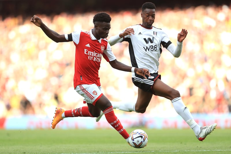 Arsenal's Bukayo Saka and Fulham's Tosin Adarabioyo battle for the ball. PA